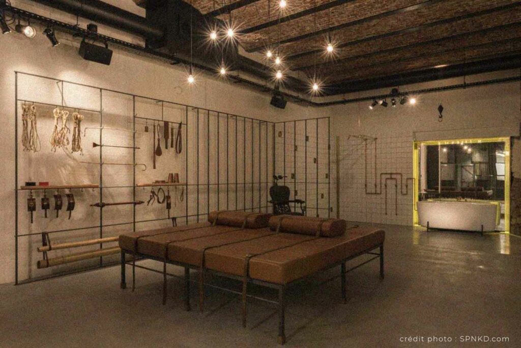 Espace intérieur de SPNKD à Anvers avec accessoires BDSM et mobilier conçu pour des expériences sensuelles.